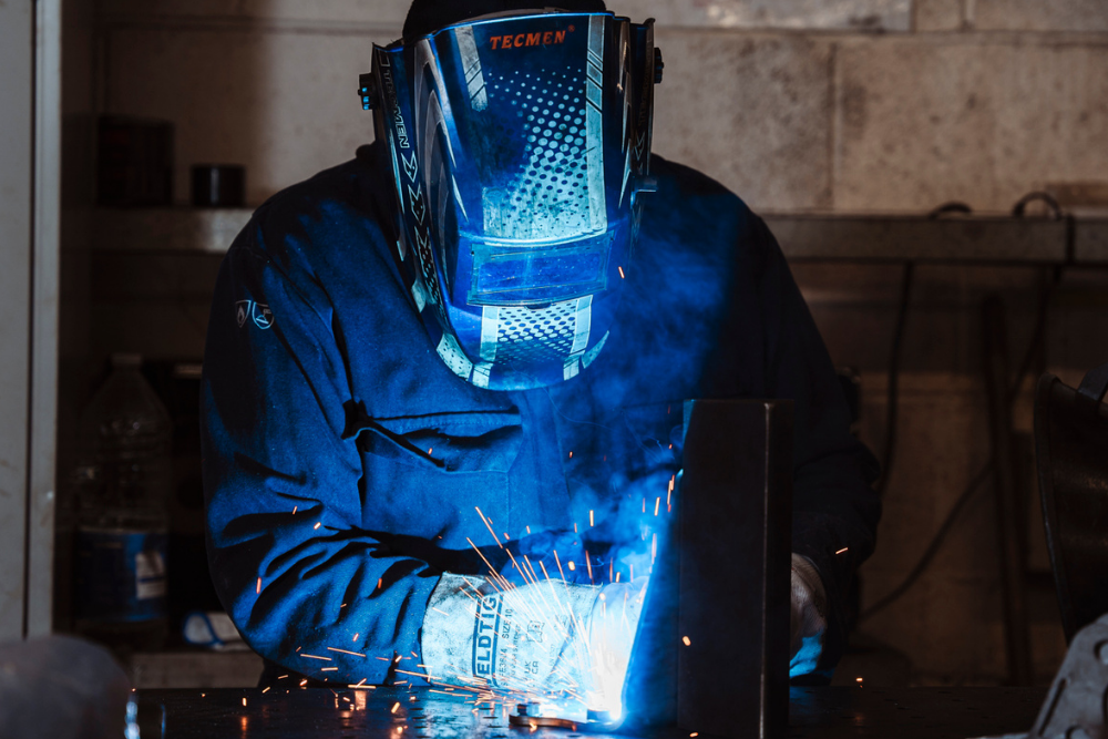 Person welding with helmet on looking down