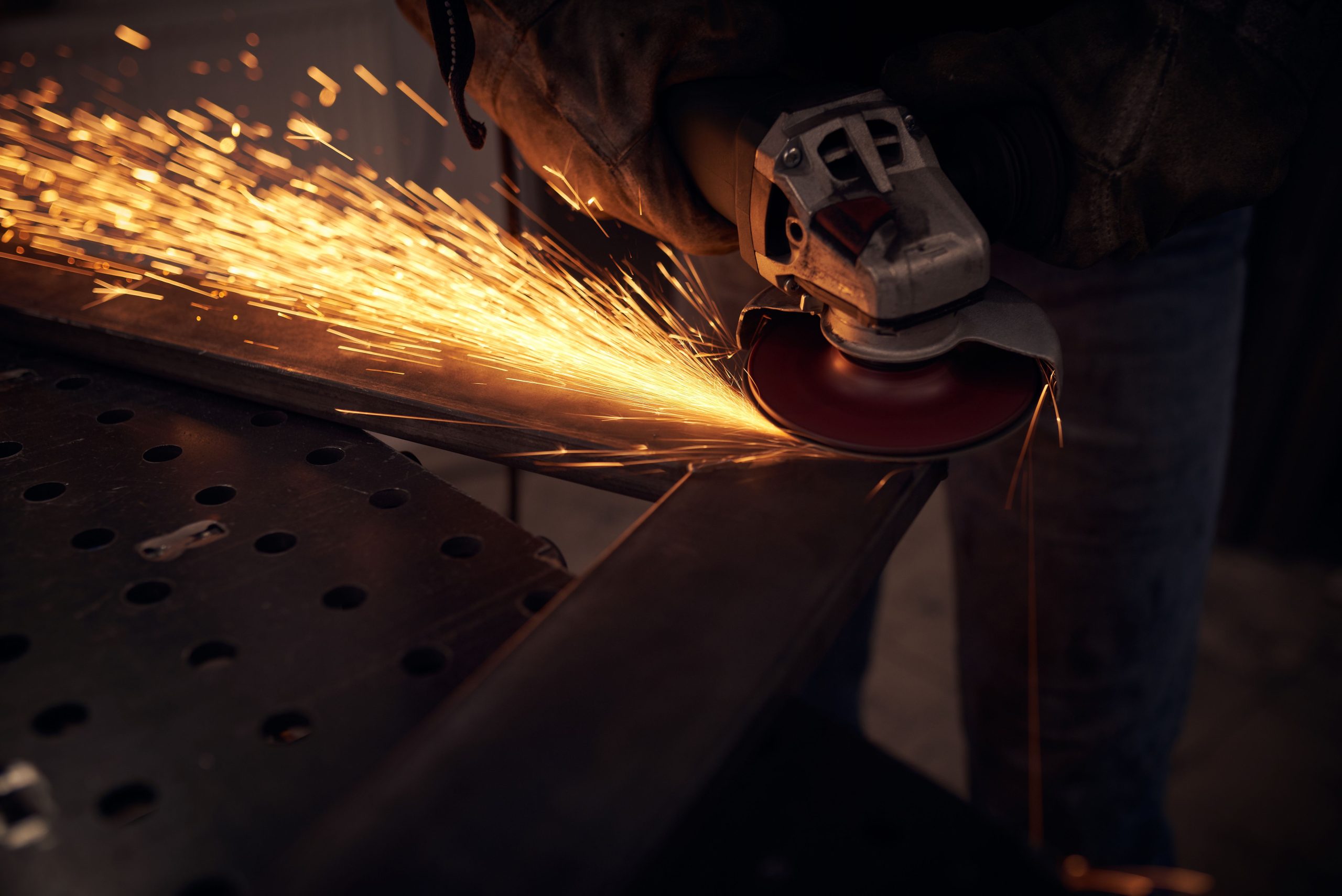 Man using a grinder to cut metal 
