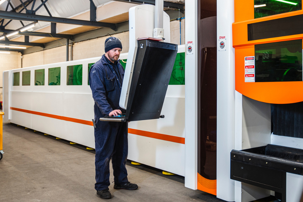 Operator working with the CNC tube laser cutting machine at Grenville Engineering.